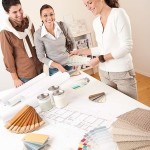 Female interior designer with two clients at office making selections