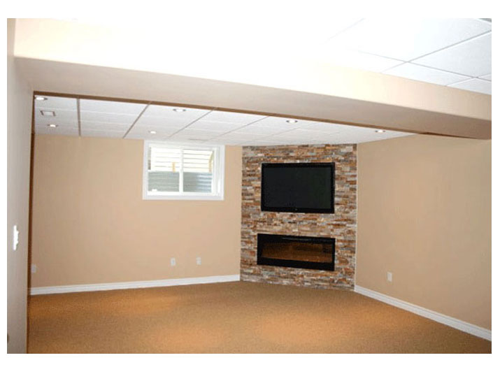 Fireplace with stone accent wall in basement family room
