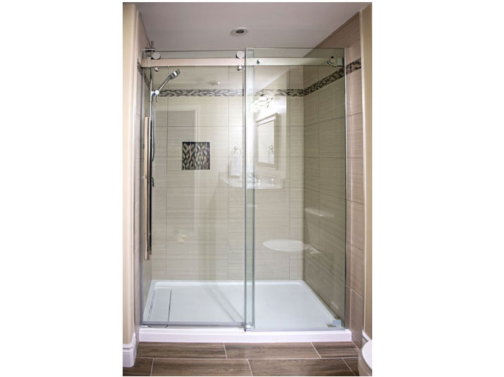 Tiled shower with frameless glass door and panel