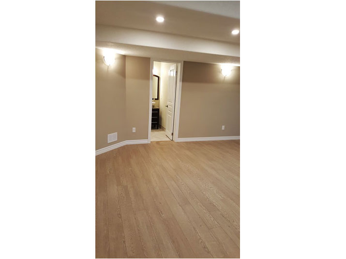 Basement living room space with oak laminate flooring