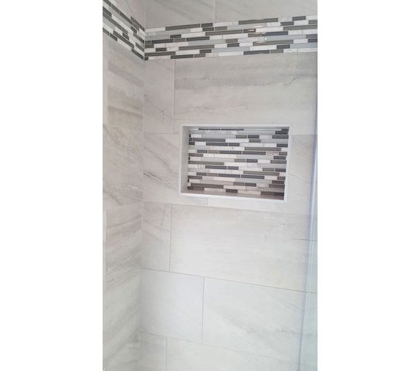 Shower niche with stone and glass mosaic tile