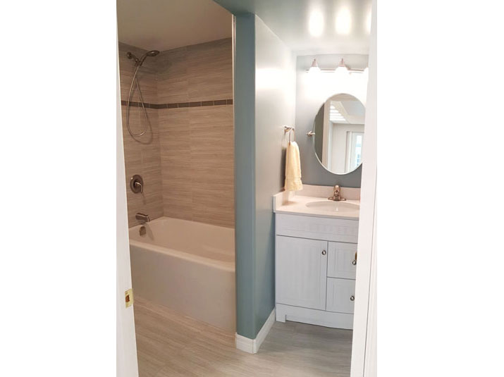 Three-piece bathroom with alcove shower with gray glazed porcelain subway tiles