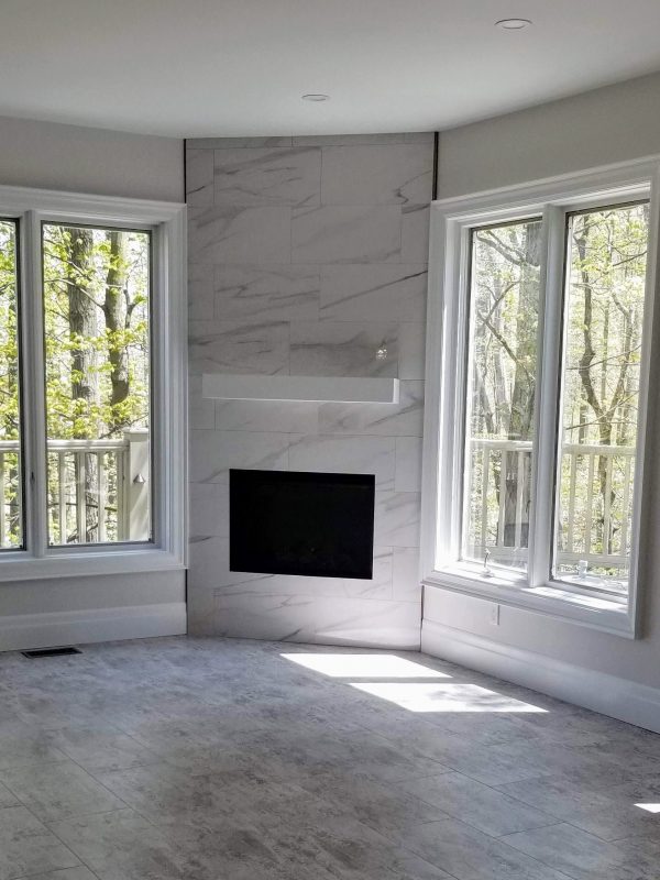 Fireplace featuring white marble tile surround and white mantel