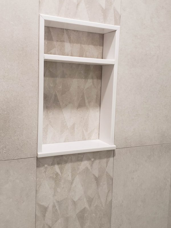 Accent tile in shower featuring quartz niche