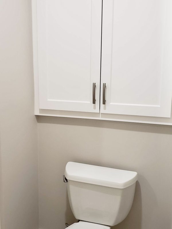 A new toilet was installed with cabinet doors