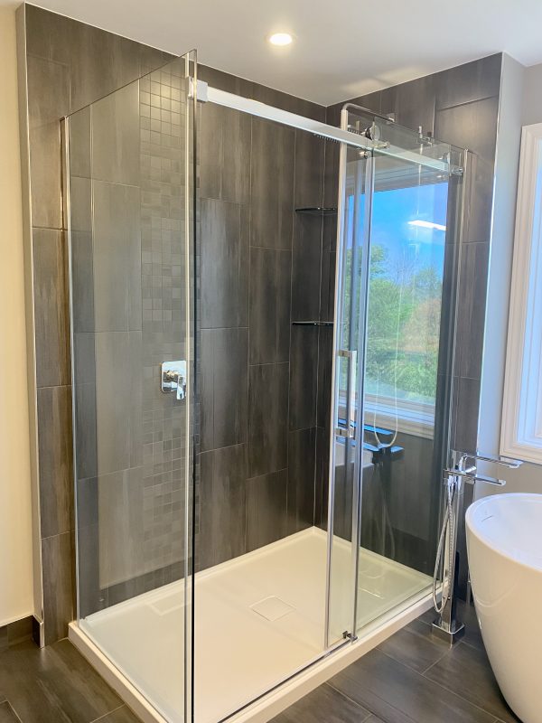 Corner shower installed with a sliding glass door system