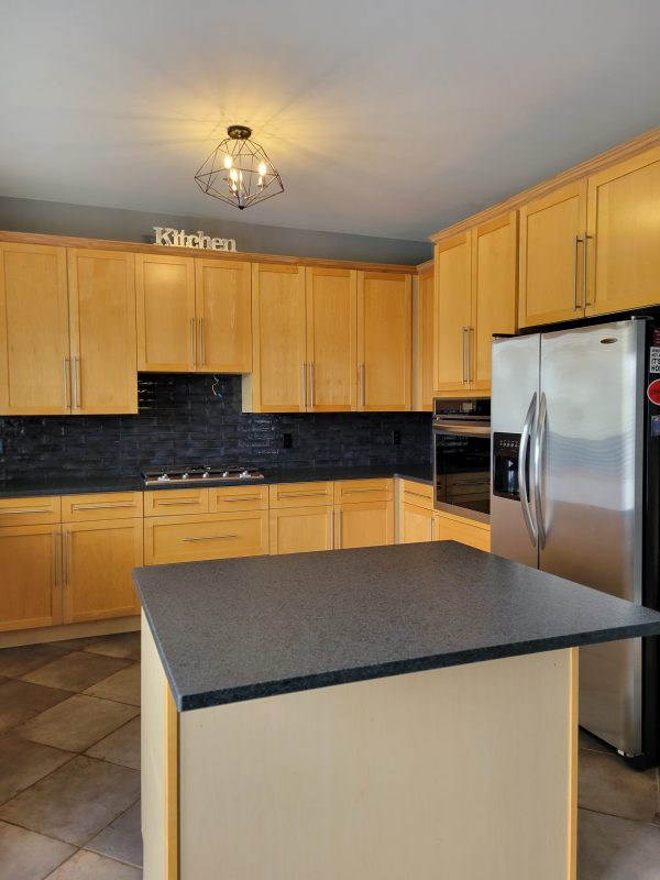 Kitchen reface featuring new granite countertops, backsplash and stove top