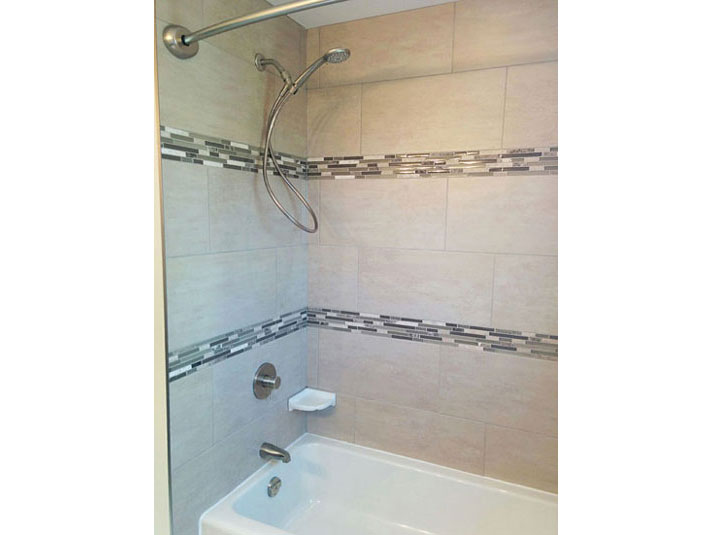 Bathtub/shower with mosaic tile accent borders