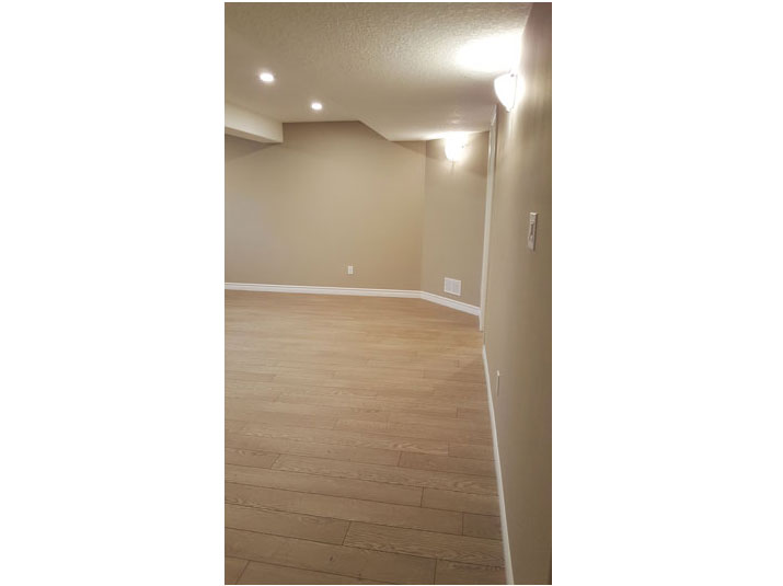 Basement living room space with oak laminate flooring
