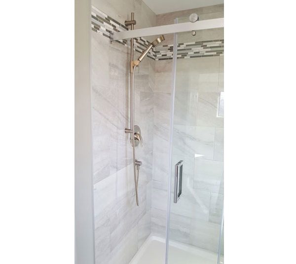 Walk-in shower with porcelain subway tiled walls and mosaic tile accent border