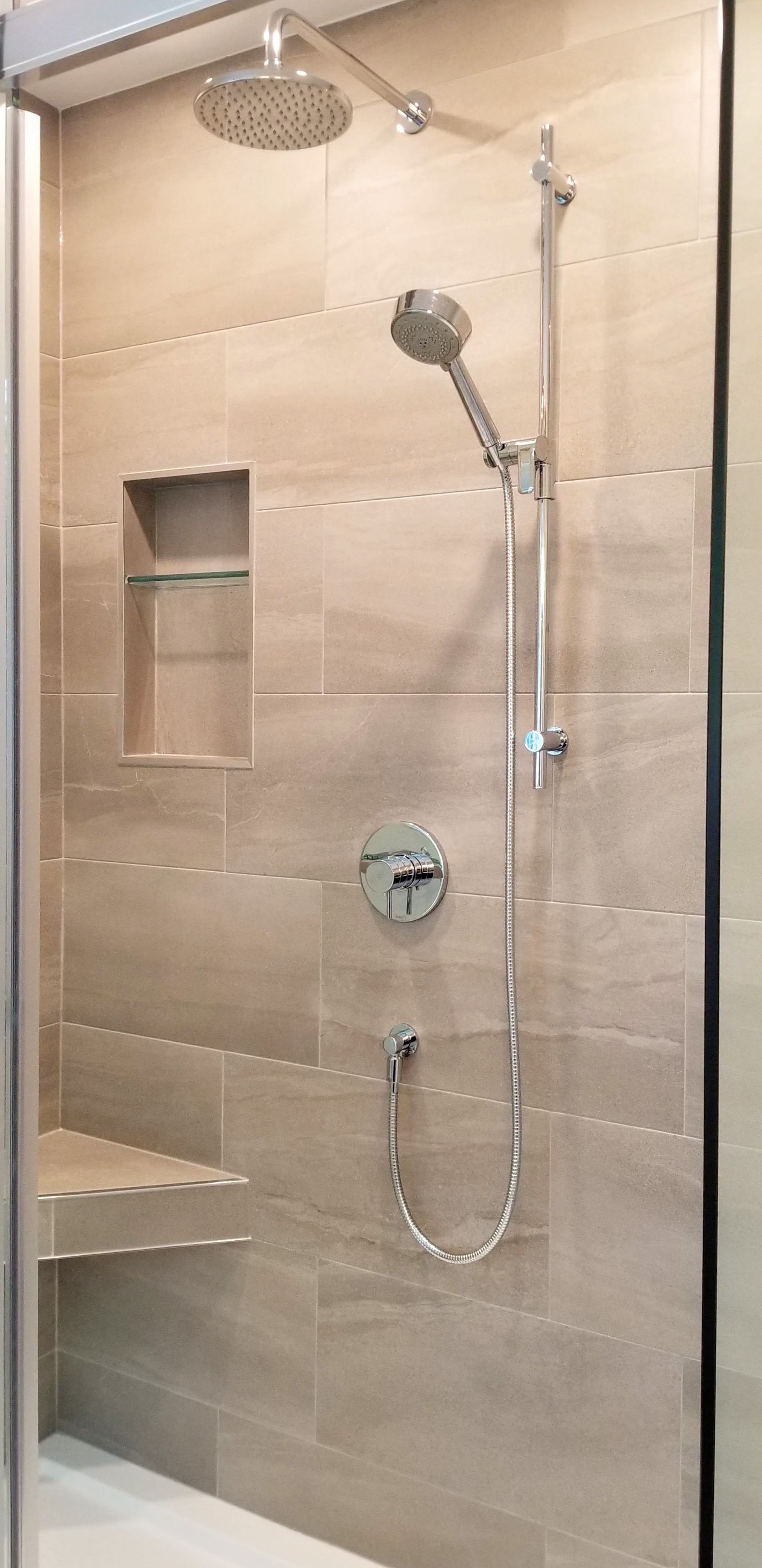 Tiled shower with niche installed in ensuite bathroom by Germano Creative Interior Contracting Ltd.