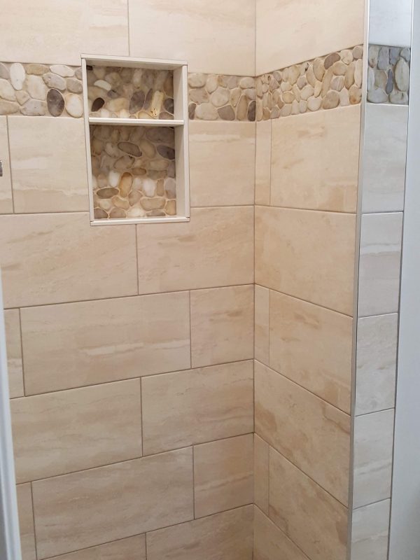 Shower niche with pebble stone accent border