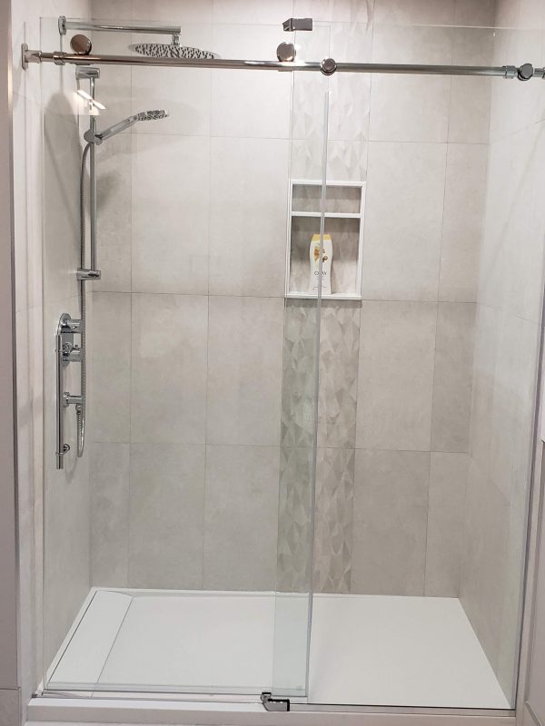 Sliding glass shower doors featuring porcelain tile shower surround