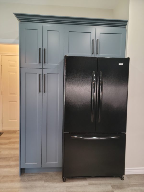 Pantry surrounding fridge featuring new crown moulding