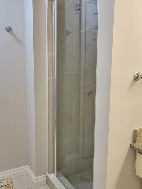 New porcelain tile shower installed with glass door system