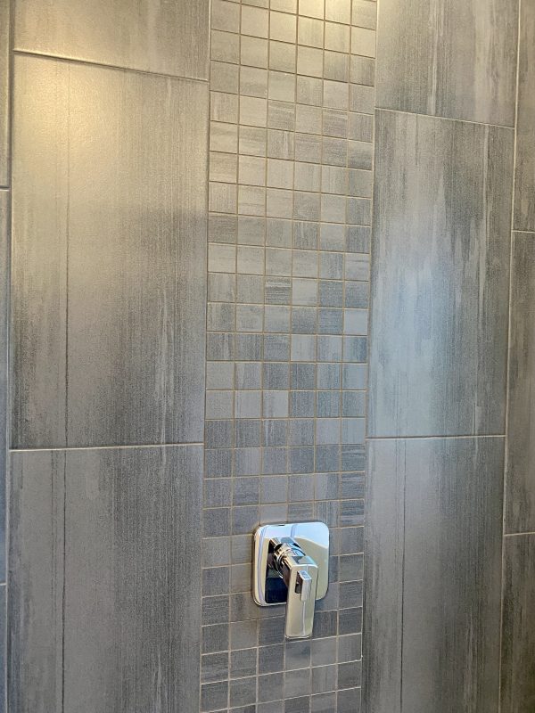 Porcelain tile was installed for the shower surround. featuring an accent border