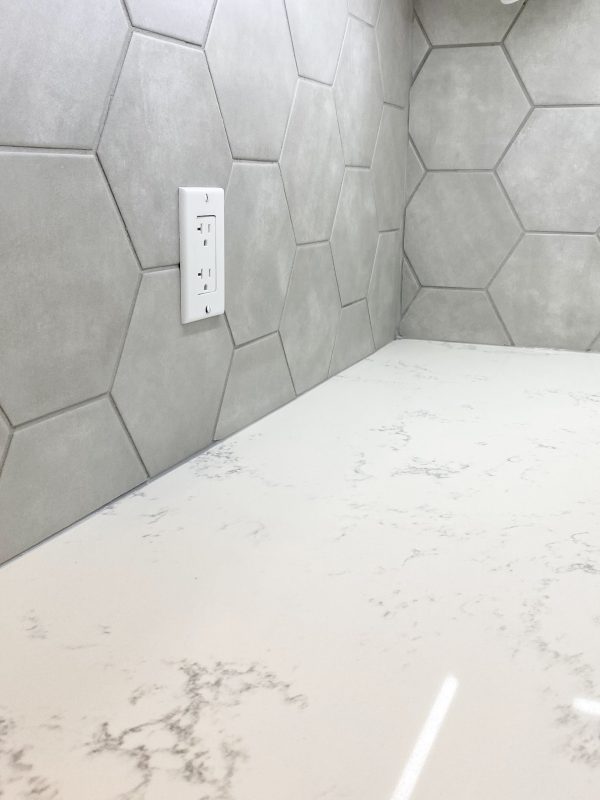 Quartz countertop featuring hexagon tile backsplash