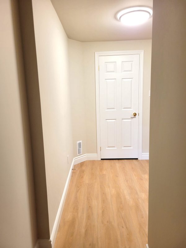 Flooring continued into basement hallway leading to washroom
