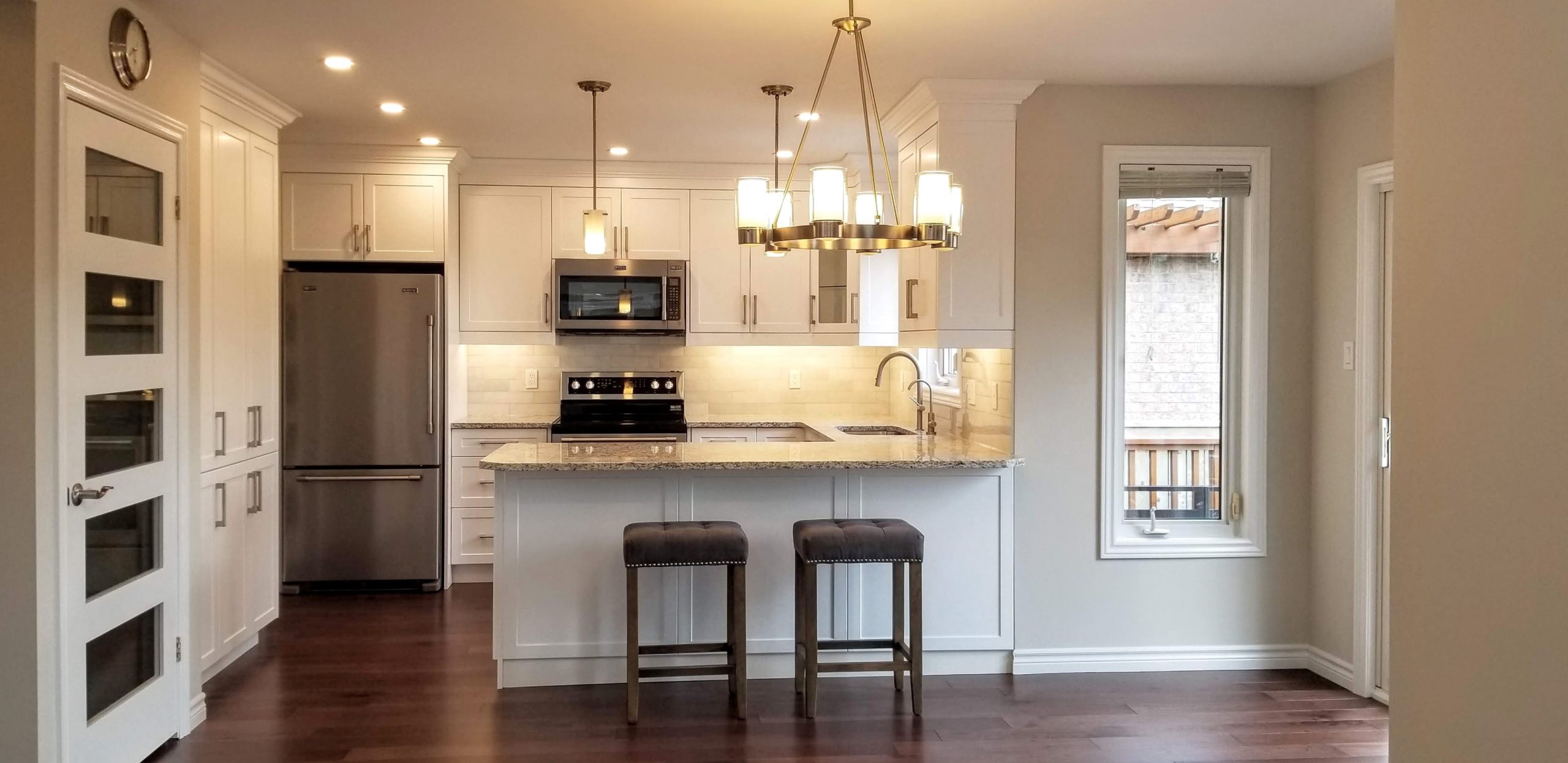 Classy white kitchen featuring white granite countertops