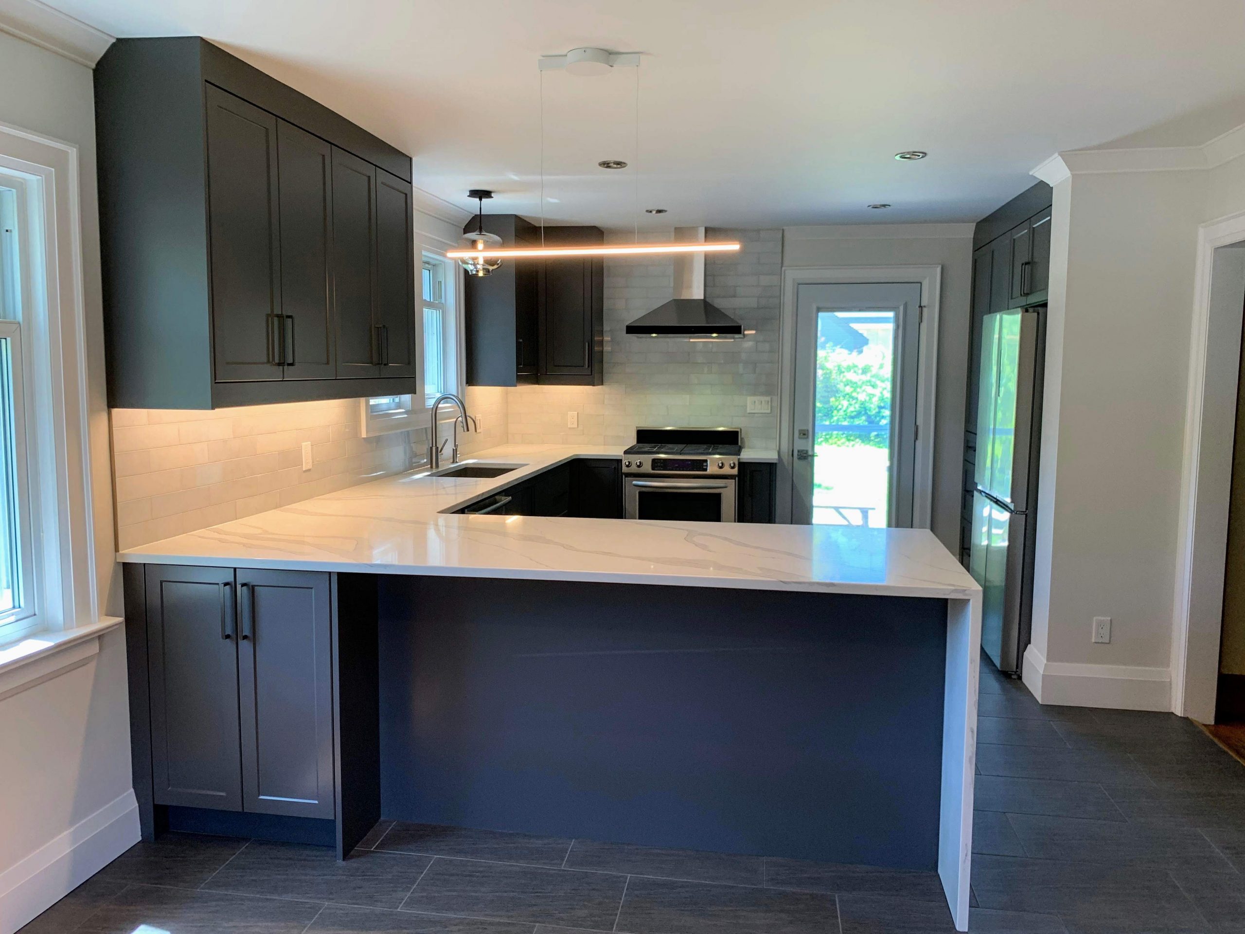 Modern kitchen renovation featuring marble waterfall countertop