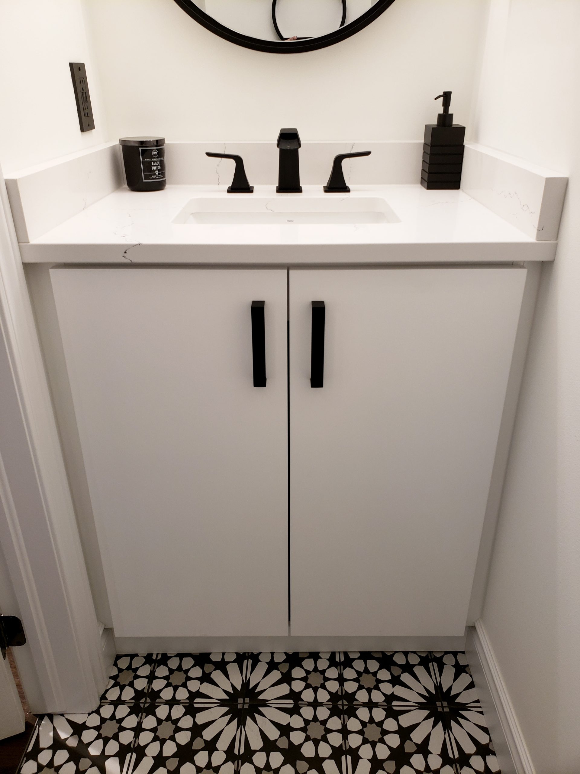White vanity installed featuring quartz countertops