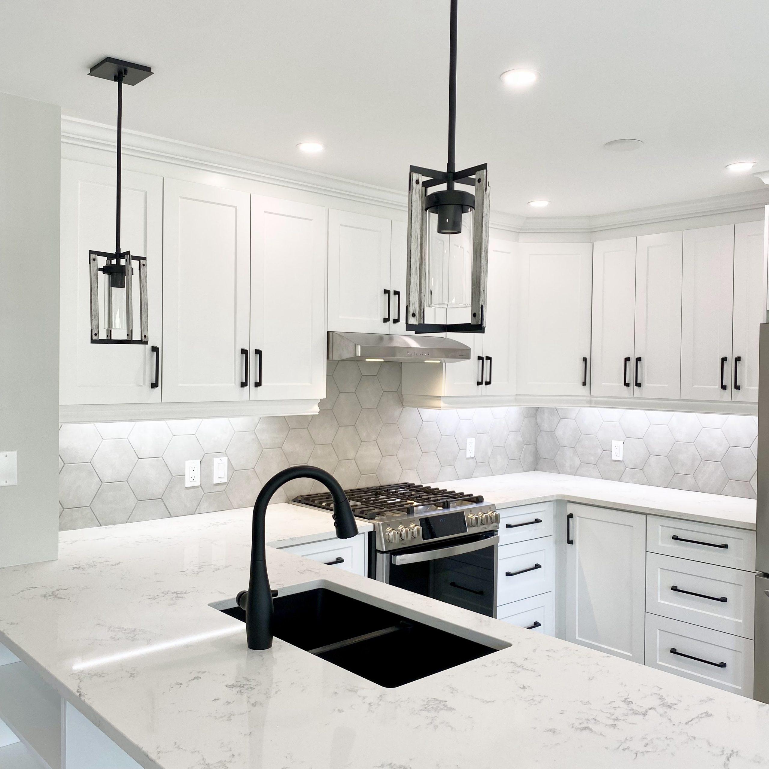 Black pendant lighting installed above peninsula