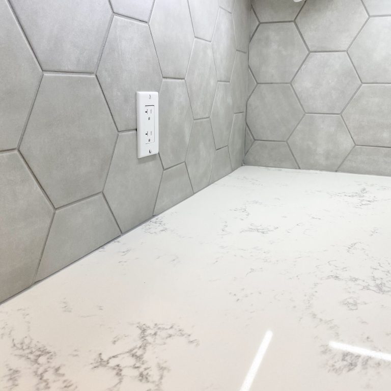 Quartz countertop featuring hexagon tile backsplash